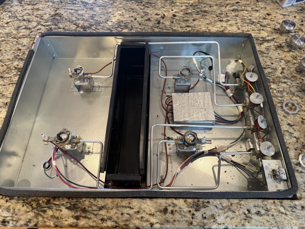 Exposed stove control panel wiring showing common appliance emergencies requiring urgent professional repair to prevent electrical hazards.