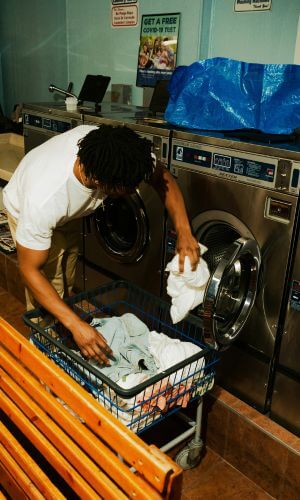 Homeowner preparing to dry laundry in a commercial machine—experiencing issues with a dryer not heating up