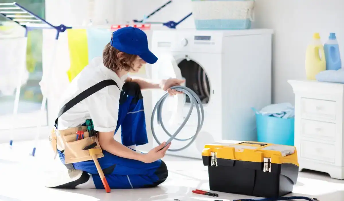 Appliance repair technician checking hose and tools to diagnose common issues causing washing machine not spinning properly.